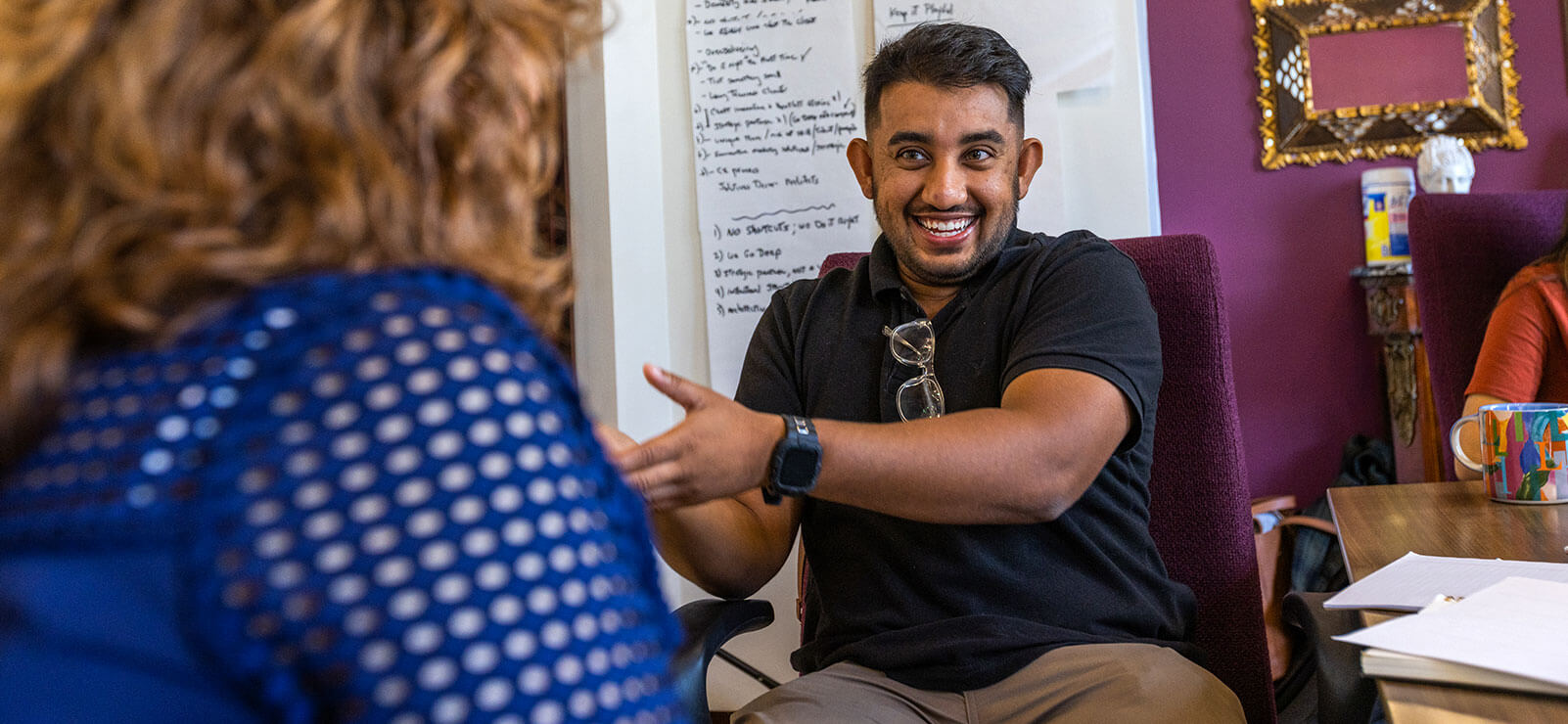 Mo Mostafa smiles while discussing initiatives with a TELL ME MORE team colleague