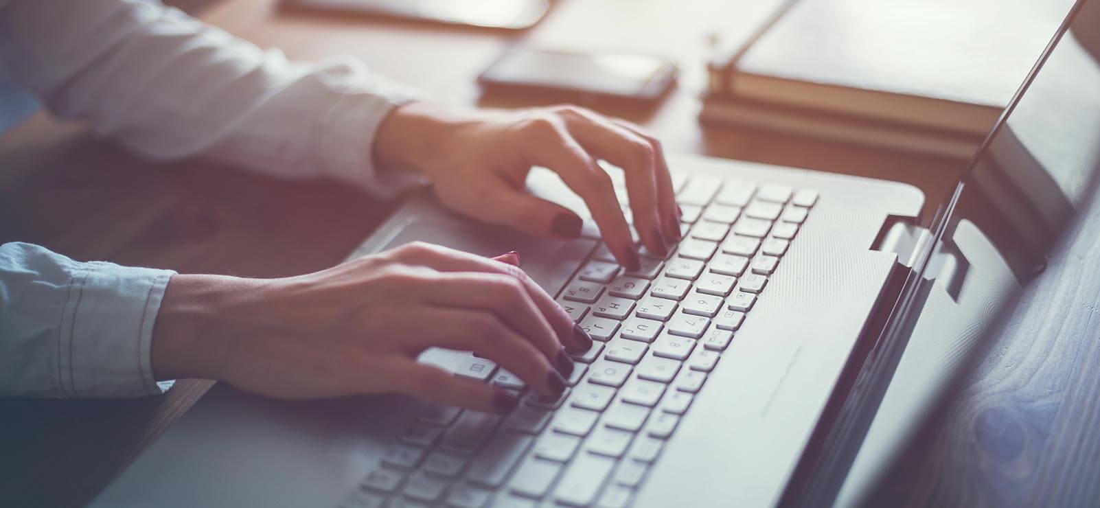 Woman's hands typing on a laptop computer